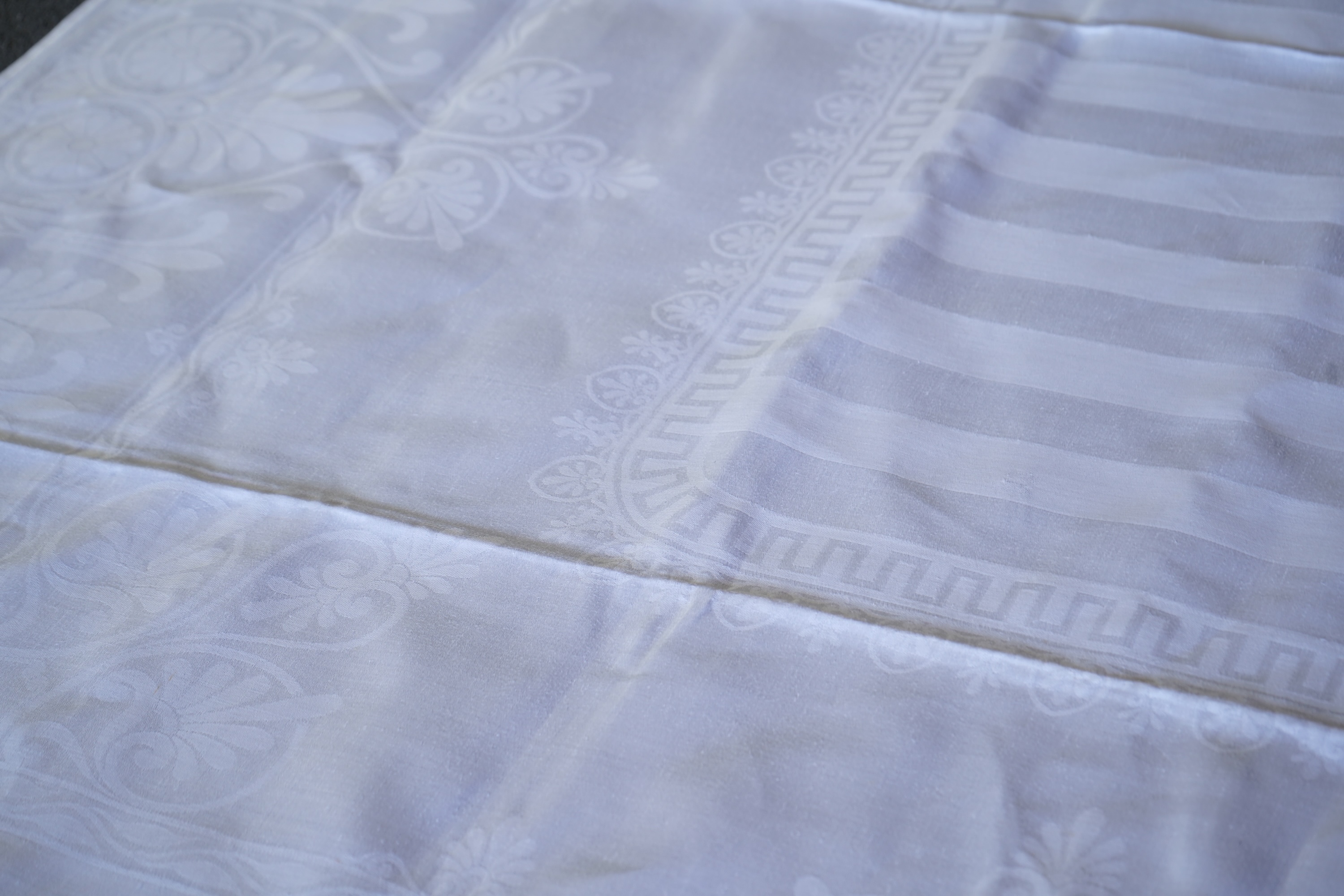 A late 19th century large white Irish damask table cloth, woven with an all over Christopher Dresser ‘inspired’ design. The overall design incorporating many of his known stylistic design motifs. Each corner has a shamro